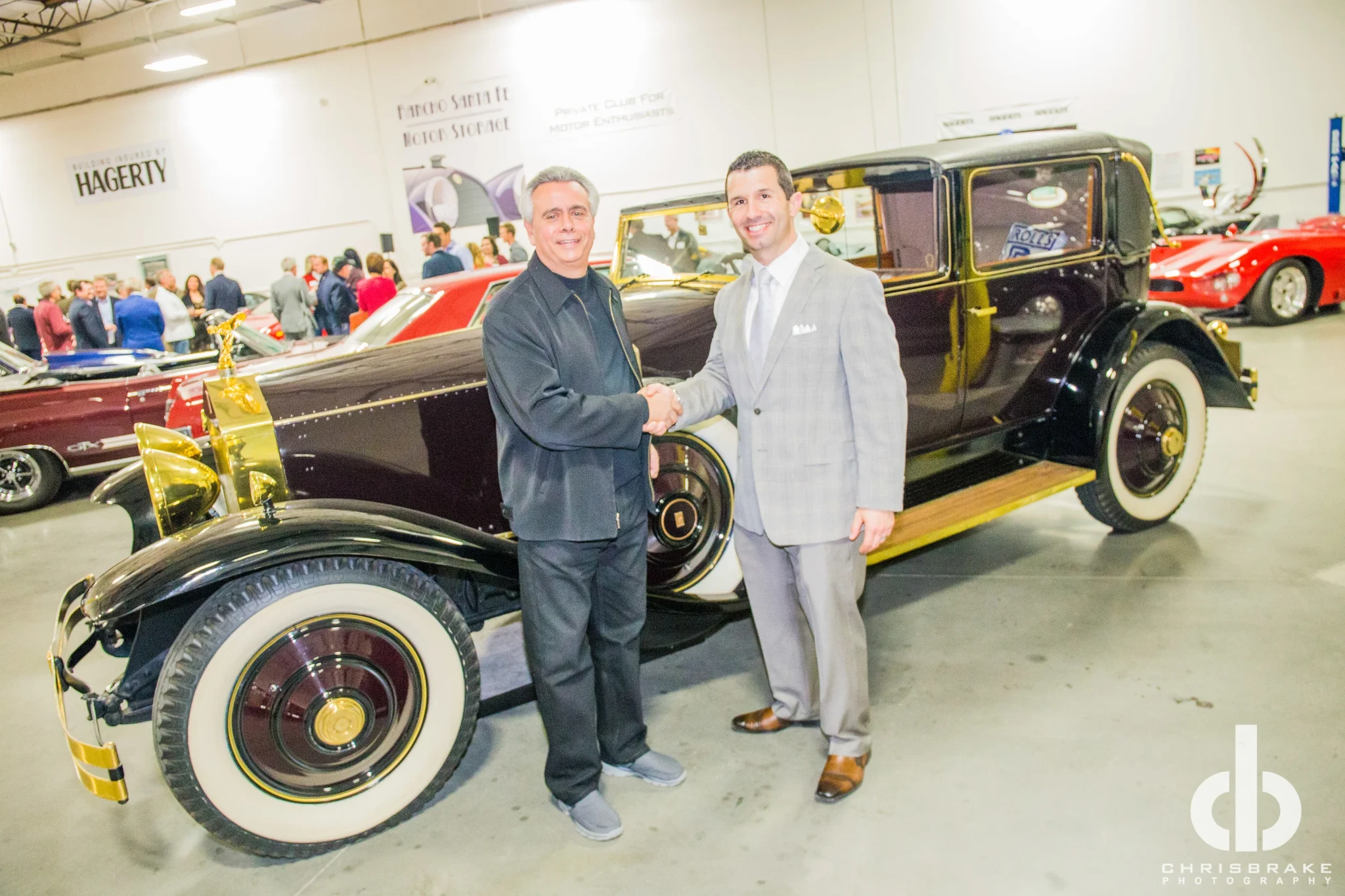 SIR ALFRED J DIMORA, CEO OF DIMORA MOTORCAR, SHAKING HANDS WITH NINO VENTURELLA, CEO OF CRUISE 4 KIDS. THE VEHICLE BEHIND THEM IS A BURGANDY 1931 ROLLS ROYCE PHANTOM II WITH GOLD PACKAGE THAT WAS DONATED TO CRUISE 4 KIDS IN 2014. PHOTO BY: CHRIS BRAKE PHOTOGRAPHY